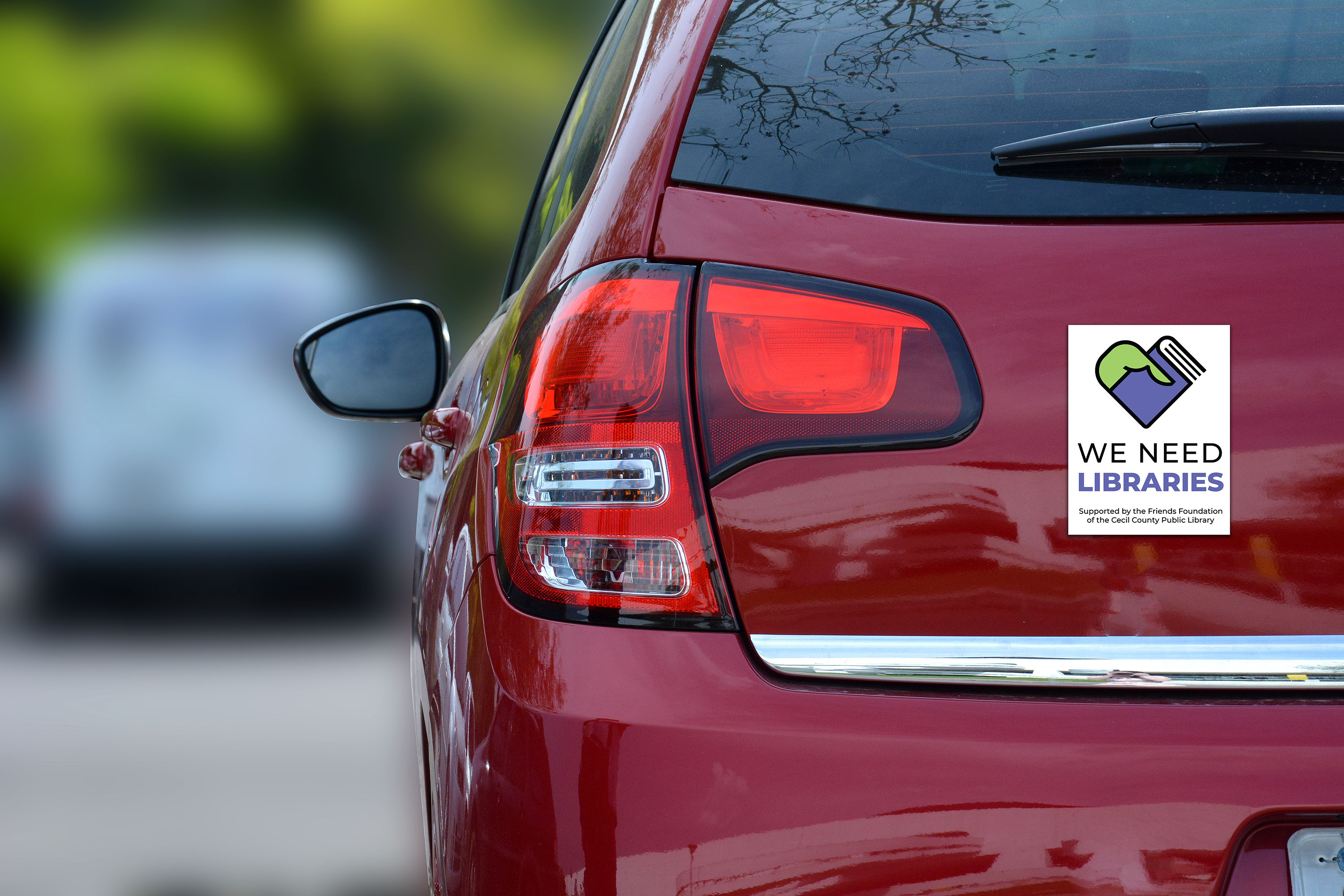 We Need Libraries Magnet shown on a car