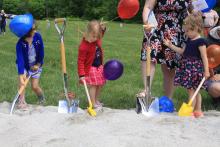 Young children with shovels playing during groundbreaking ceremony