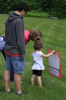 Woman, man, and toddler participating in the story walk